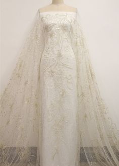 a white wedding gown on display in front of a mannequin's head