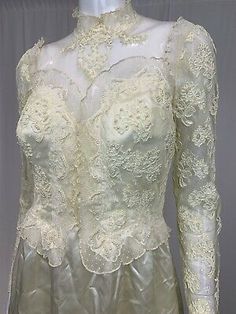 a white dress with lace on the neck and sleeves, in front of a mannequin