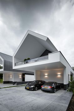 two cars are parked in front of a house with white walls and windows on the roof