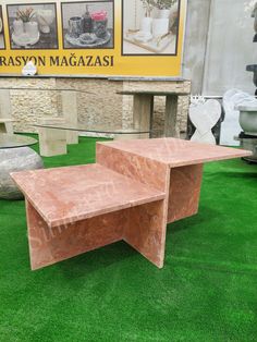 two tables sitting on top of green grass in front of a store sign and pictures