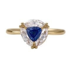 a yellow gold ring with two pear shaped diamonds and a blue sapphire in the center