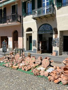 there are many pots and vases on the ground outside an old building with balconies