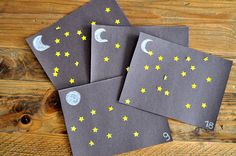 three cards with yellow stars and the moon on them are sitting on a wooden table