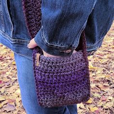 a woman is holding a crocheted purse in her left hand and jeans on the other side