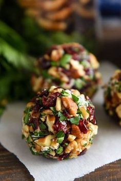 three cookies with nuts and cranberry toppings on top of white paper towel