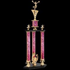 a pink and gold trophy sitting on top of a black table