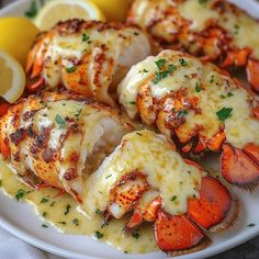 cooked lobsters on a plate with lemon wedges and parsley garnish