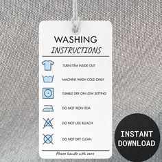 a tag with instructions for washing clothes hanging from a hook on a gray fabric background