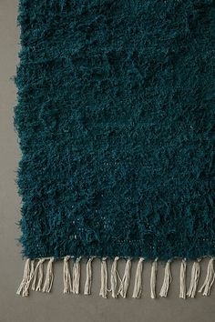 a blue rug with tassels on top of it