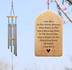 a wind chime hanging from a tree branch with a poem written on the front