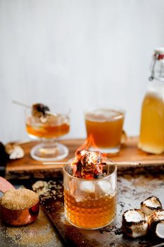 an assortment of desserts and drinks on a metal tray next to a wooden spoon