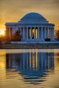 the jefferson memorial at sunset reflecting in the water