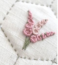 a close up of a piece of fabric with flowers on it and stitching in the background