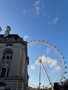 a large ferris wheel sitting next to tall buildings