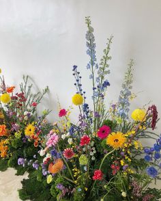 an arrangement of wildflowers and other flowers on display