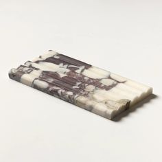 a white and brown marble business card holder on a white surface with an image of horses