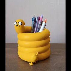 a yellow container with pens and pencils in it