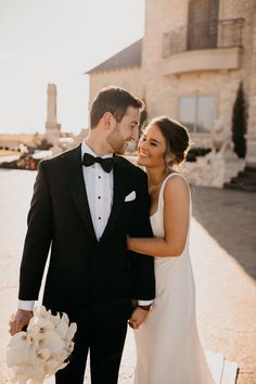 a bride and groom smile at each other