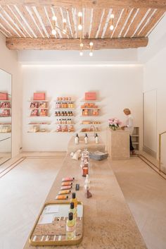 an empty room with shelves and bottles on the wall next to a counter in front of it