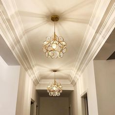 an empty hallway with chandeliers hanging from the ceiling