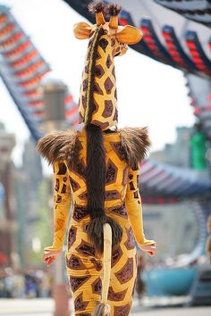 a woman in a giraffe costume walking down the street