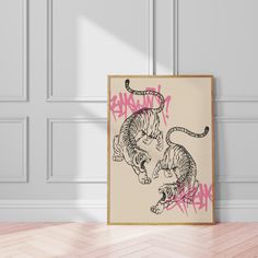 a poster with two cats on it in front of a white wall and wooden floor