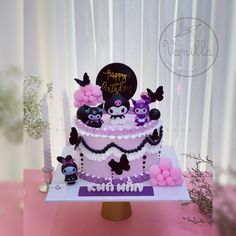 a birthday cake is decorated with purple and black decorations