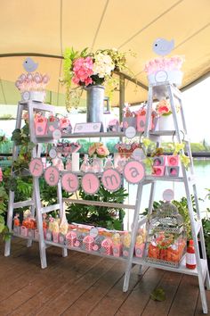 a table with pink and white decorations on it in front of a tented area