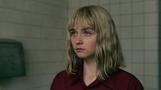 a woman with blonde hair standing in a bathroom