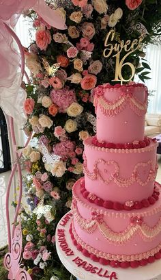 a three tiered pink wedding cake sitting on top of a table