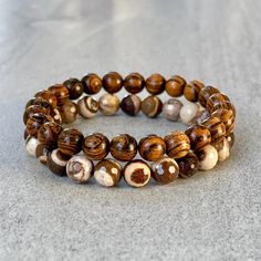 Men's beaded bracelet made with strong, stretchy cord and genuine/natural gemstones and wood. Features ~ 6mm/8mm/10mm tiger skin sandalwood beads ~ 6mm/8mm/10mm faceted brown zebra jasper beads ~ Stretchy cord; simply slide bracelet on and off wrist ~ Comes packaged in a re-usable microfiber pouch To ensure the perfect fit, please use the bracelet sizing instructions found in the photo gallery. Refund Policy: Items can be returned for refund (less shipping costs) within 14-days.  All items must be in new/unworn condition.  If items are not returned in new/unworn condition, they will be sent back at buyer's expense. Stacked Beaded Bracelets, Tiger Skin, Slide Bracelet, Zebra Jasper, Jasper Bracelet, Onyx Bracelet, Mens Beaded Bracelets, Lava Bead, Onyx Bead