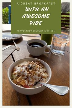 a bowl of food sitting on top of a wooden table next to a cup of coffee