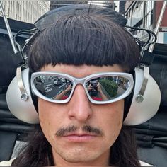 a man with long hair wearing headphones and sunglasses