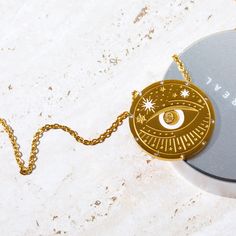 Our Celestial Coin Medallion Necklace—a captivating accessory inspired by the celestial wonders of the universe. This necklace features a stunning coin-shaped pendant crafted in gold, adorned with celestial motifs that evoke a sense of mystery and magic. With three distinct styles to choose from—moon phase, sun and moon, and evil eye—this necklace allows you to express your unique style while embracing the celestial energies that surround us. Celestial Motifs, Gemstone Candles, Mantra Bracelet, Boho Tote Bag, Buddha Bracelets, Zodiac Bracelet, Evil Eye Earrings, Evil Eye Ring, Moon Sun