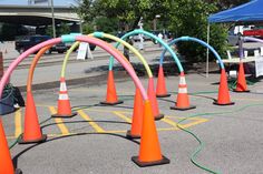 an array of orange and blue cones with hoses connected to them on the pavement