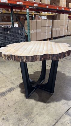 a wooden table with black metal legs in a warehouse