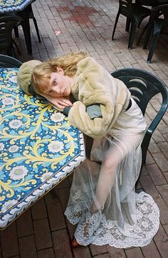 a woman is sleeping on a table outside