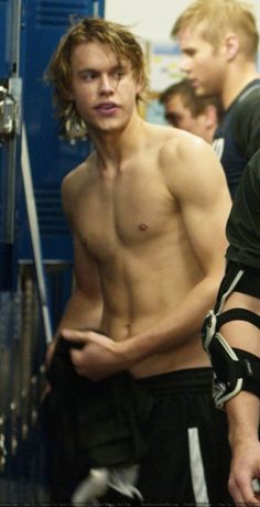 two young men standing next to each other in front of lockers with no shirts on