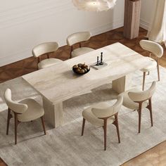 a dining table with chairs around it and a rug on the floor in front of it