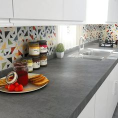 a kitchen counter top with food on it and jars of jams in the background