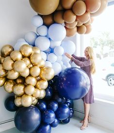 a woman standing next to balloons in front of a window