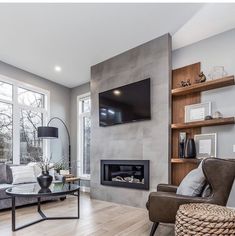 a living room with couches, chairs and a television mounted on the wall in front of a fireplace