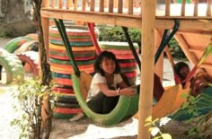 two women are sitting in colorful hammocks on the playgrounds at an amusement park