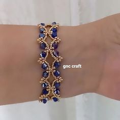 a woman's arm wearing a gold bracelet with blue stones and beads on it