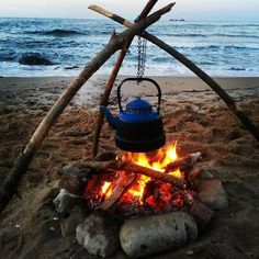 a kettle is sitting on top of a campfire