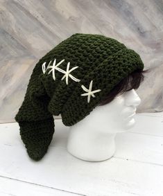 a crocheted hat with white stars on the front and side, sitting on top of a mannequin head