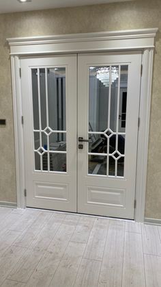 two white double doors with glass panels in a room