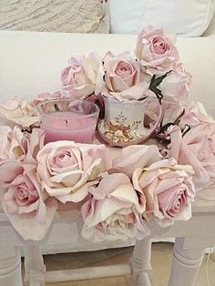 a white table topped with pink roses and candles