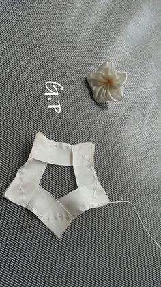 two pieces of white fabric next to a flower