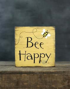 a wooden sign that says bee happy with a bee on it's side and the words bees are written in black ink